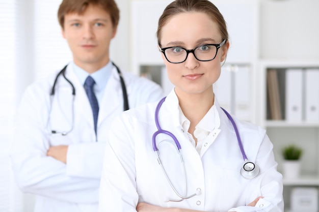 Heureuse femme médecin avec du personnel médical à l'hôpital