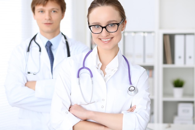 Heureuse femme médecin avec du personnel médical à l'hôpital