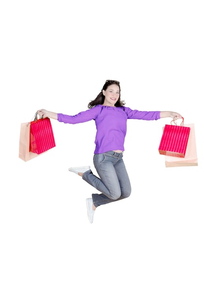 Heureuse femme métisse avec des sacs à provisions isolés sur blanc