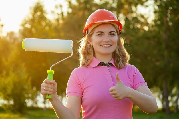 Heureuse femme mettant un casque casque dans l'idée d'orientation professionnelle du parc d'été