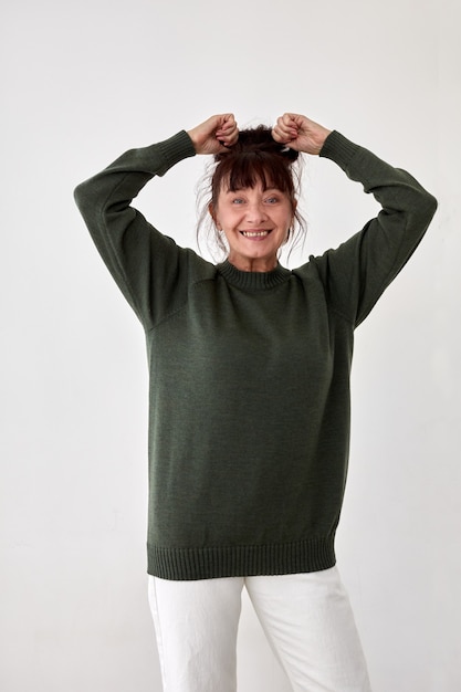 Photo heureuse femme mûre en pull vert chaud