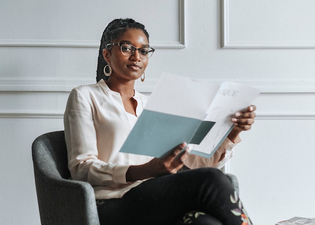 Heureuse femme noire lisant un magazine unique