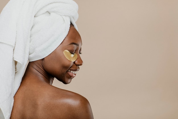 Photo heureuse femme noire portant un masque pour les yeux doré