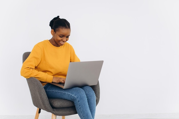 Heureuse femme noire travaillant avec un ordinateur portable à la maison Positive Young African American Freelancer Lady utilisant un ordinateur PC