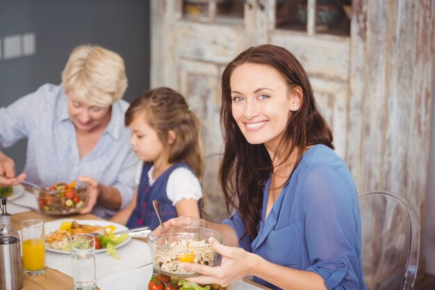 Heureuse femme prenant son petit déjeuner en famille