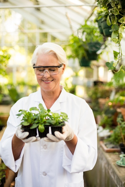 Heureuse femme scientifique tenant des plantes