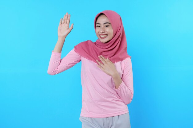 Heureuse femme souriante avec une apparence attrayante et portant le hijab, t-shirt rose montrant dire bonjour sourire bonne humeur