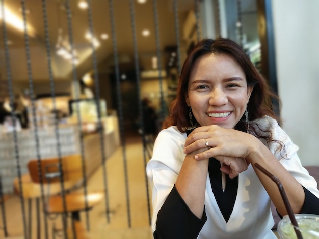 Heureuse femme souriante au café