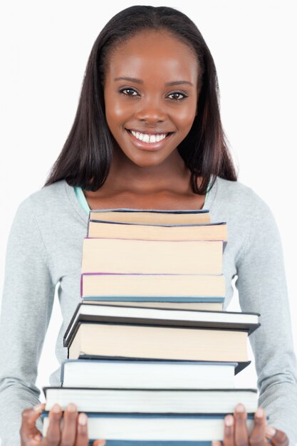 Heureuse femme souriante avec une pile de livres