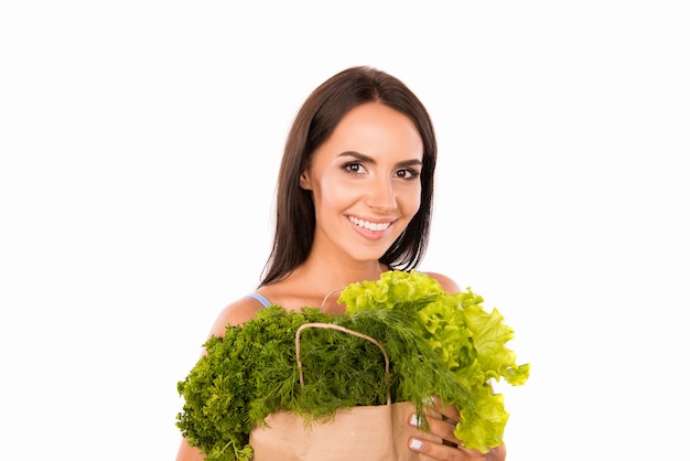 Heureuse femme souriante avec sac plein de légumes verts et de légumes