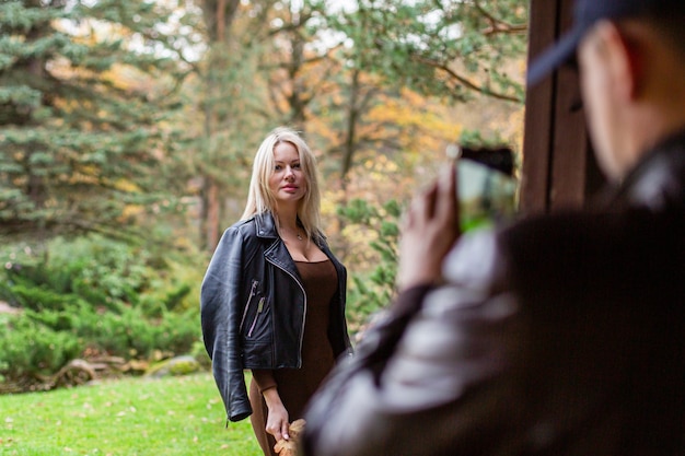 Photo heureuse femme souriante tenant dans ses mains des feuilles d'érable jaune