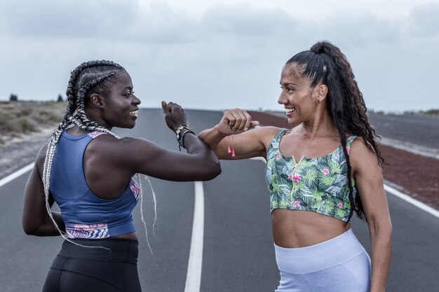 Heureuse femme sportive se saluant avec le coude