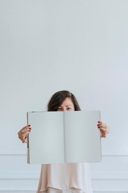 Heureuse femme tenant un cahier vide