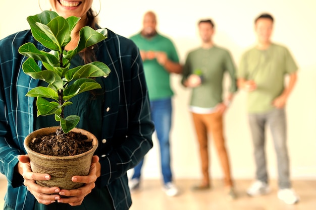 Photo heureuse femme tenant une plante