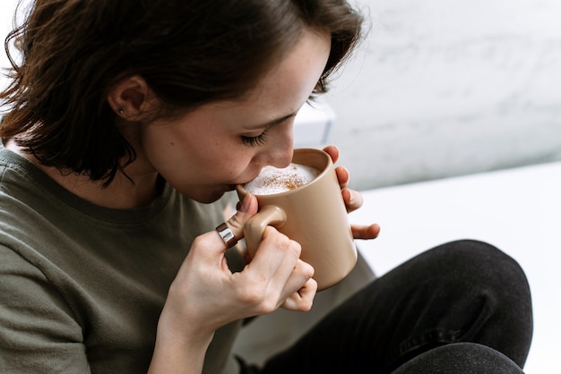 Heureuse femme tenant une tasse de café