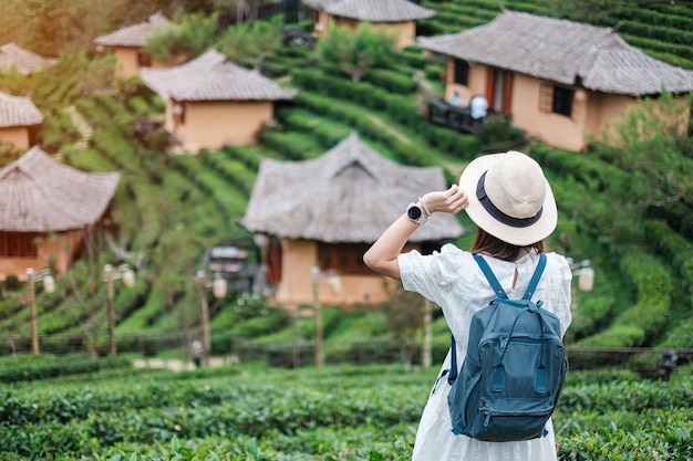 Heureuse femme touristique en robe blanche profiter du beau jardin de thé.