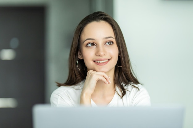 Heureuse femme utilisant un ordinateur portable dans la salle de cuisine