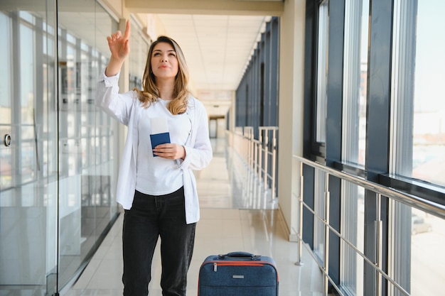 Photo heureuse femme voyageant et marchant à l'aéroport