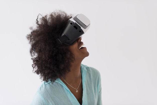 Heureuse fille afro-américaine acquérir de l'expérience en utilisant des lunettes de casque VR de réalité virtuelle, isolée sur fond blanc