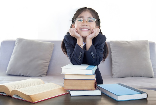 Heureuse fille asiatique avec livre de lecture dans le salon