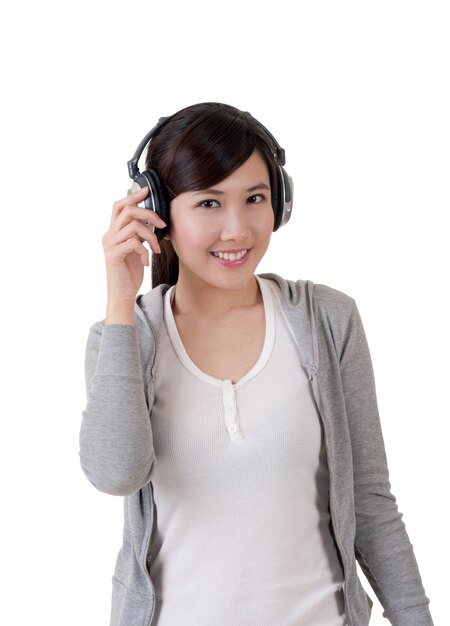 Heureuse fille asiatique souriante avec un casque, portrait de concept de musique sur fond blanc.