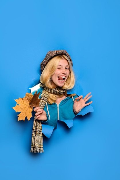 Heureuse fille d'automne clin d'œil joyeuse femme insouciante montre un signe ok fille clignant de l'œil avec des feuilles à la recherche