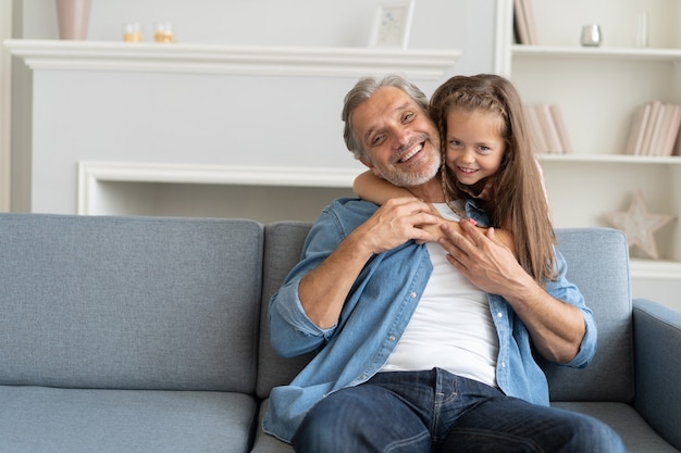 Heureuse fille douce embrassant son père à la maison.