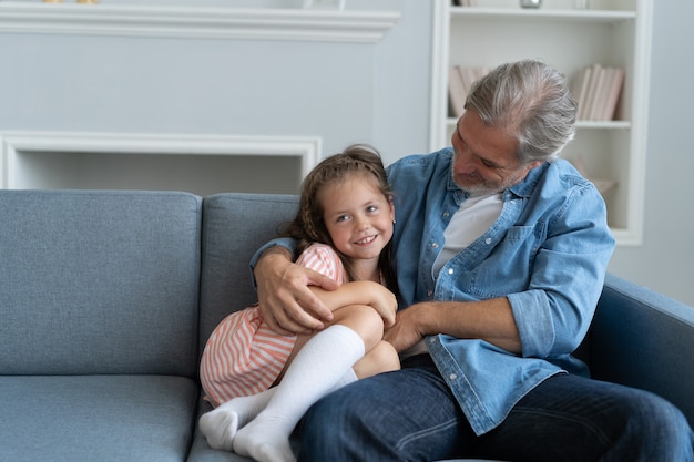 Heureuse fille douce embrassant son père à la maison.