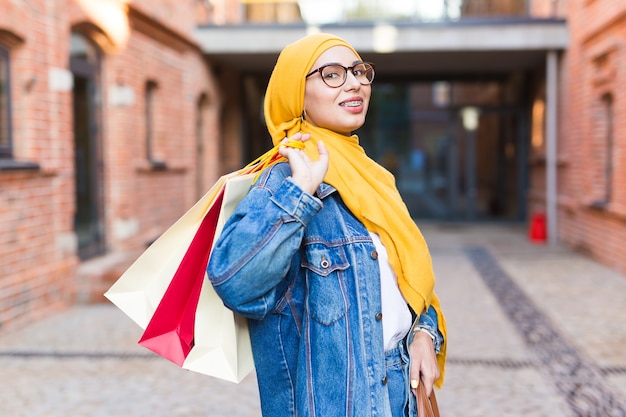 Heureuse fille musulmane arabe avec des sacs à provisions