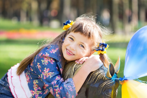 Heureuse fille qui rit sur l'herbe Enfant souriant à l'extérieur