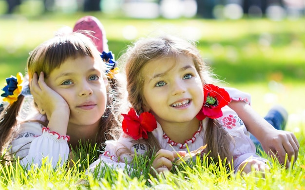 Heureuse fille qui rit sur l'herbe Enfant souriant à l'extérieur