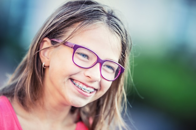 Heureuse fille souriante avec un appareil dentaire Jeune jolie fille blonde caucasienne portant un appareil dentaire