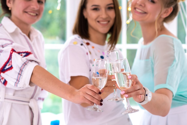 Heureuse filles élever des verres avec du champagne à la fête