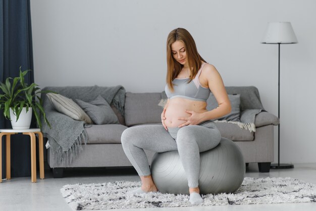 Heureuse future mère faisant des exercices de pilates