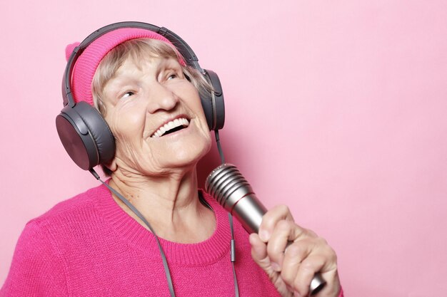 Heureuse grand-mère avec un casque et un microphone