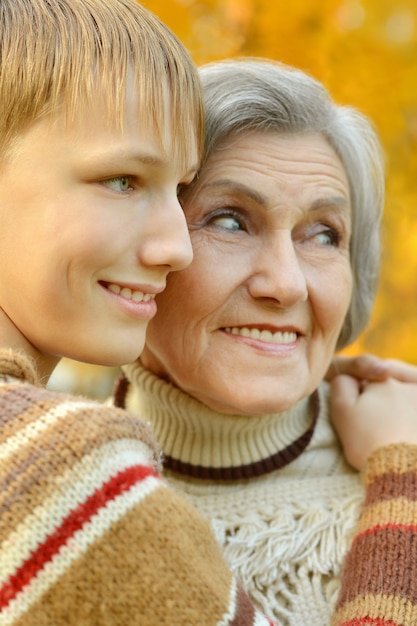 Heureuse grand-mère avec un garçon se reposant dans le parc en automne