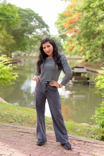 Heureuse jeune belle femme indienne souriante dans le parc en plein air