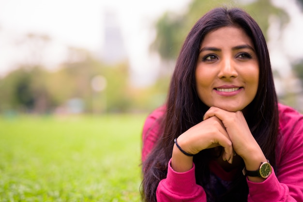 Heureuse jeune belle femme persane se détendre dans le parc