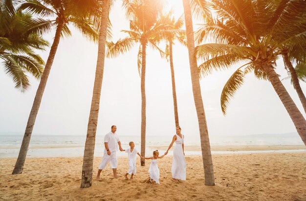 Heureuse jeune famille au coucher du soleil à la plage.