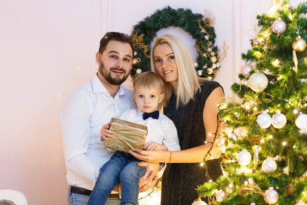 Heureuse jeune famille célébrant Noël à la maison.