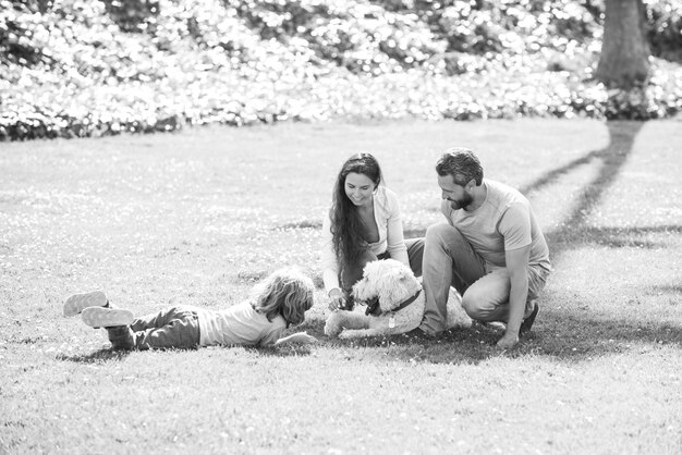 Heureuse jeune famille avec chien de compagnie passer du temps ensemble à l'extérieur dans la nature verdoyante