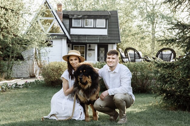 Heureuse jeune famille avec un chien sur une maison achetée avec une hypothèque