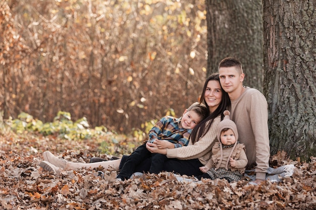 Heureuse Jeune Famille Avec Deux Petits Enfants Se Détendre Et S'amuser Dans Le Parc D'automne Aux Beaux Jours