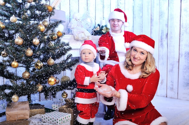 Photo heureuse jeune famille avec un enfant avec un cadeau de noël