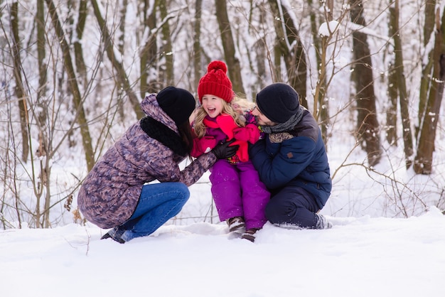 Heureuse jeune famille en hiver à l'extérieur