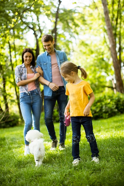 Heureuse jeune famille avec mignon chien bichon dans le parc