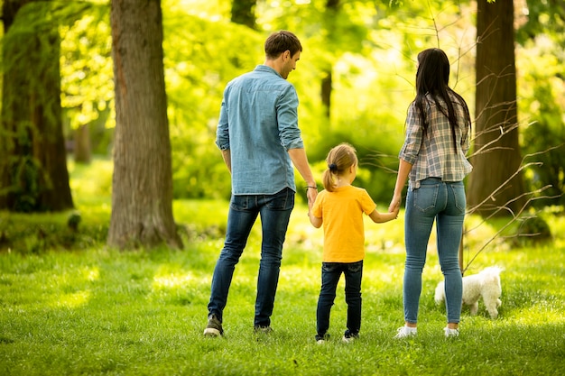 Heureuse jeune famille avec mignon chien bichon dans le parc