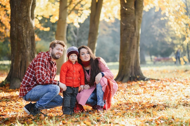 Heureuse jeune famille passant du temps en plein air dans le parc en automne