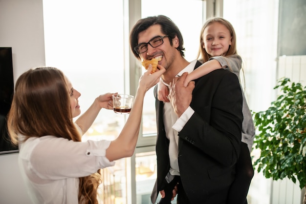 Heureuse jeune famille prend son petit déjeuner à la maison