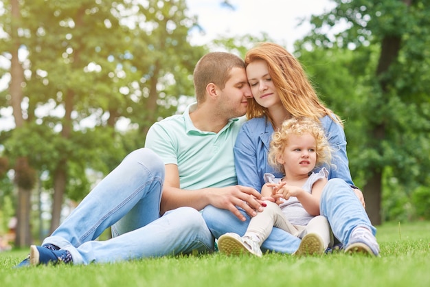 Heureuse jeune famille se détendre au parc